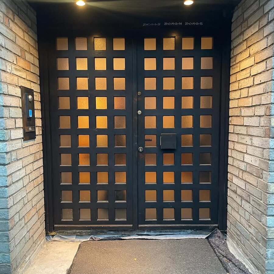 Moderne Haustür mit beleuchtetem Glasraster bei Nacht